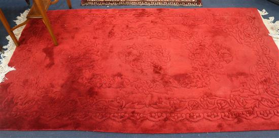 A Chinese red ground carpet, 220 x 120cm